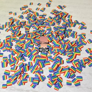 May include: A large quantity of small, colorful rainbow-striped squares. The squares are made of polymer clay and are perfect for adding a pop of color to crafts.