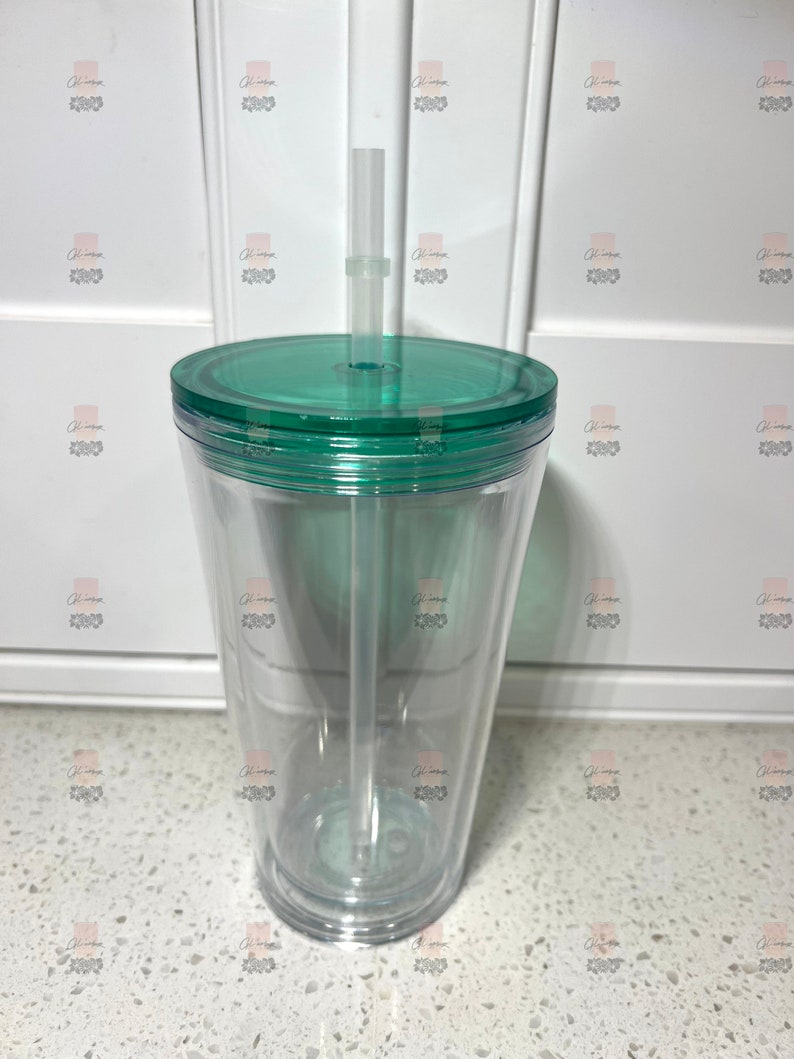 Puede incluir: Un vaso transparente de doble pared con tapa y pajita verdes. El vaso es transparente, lo que permite ver el contenido. La tapa y la pajita son de pl&aacute;stico verde a juego. El vaso est&aacute; dise&ntilde;ado para bebidas fr&iacute;as.
