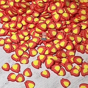 May include: A large pile of red and yellow fire-shaped confetti. The confetti is made of a soft, pliable material and is perfect for adding a festive touch to any craft project.