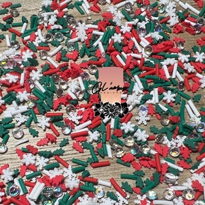 May include: A variety of Christmas sprinkles in red, white, and green. The sprinkles include small trees, snowflakes, and candy canes.
