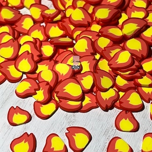 May include: A large pile of red and yellow flame-shaped resin embellishments. These are great for adding a fun and festive touch to crafts and projects.