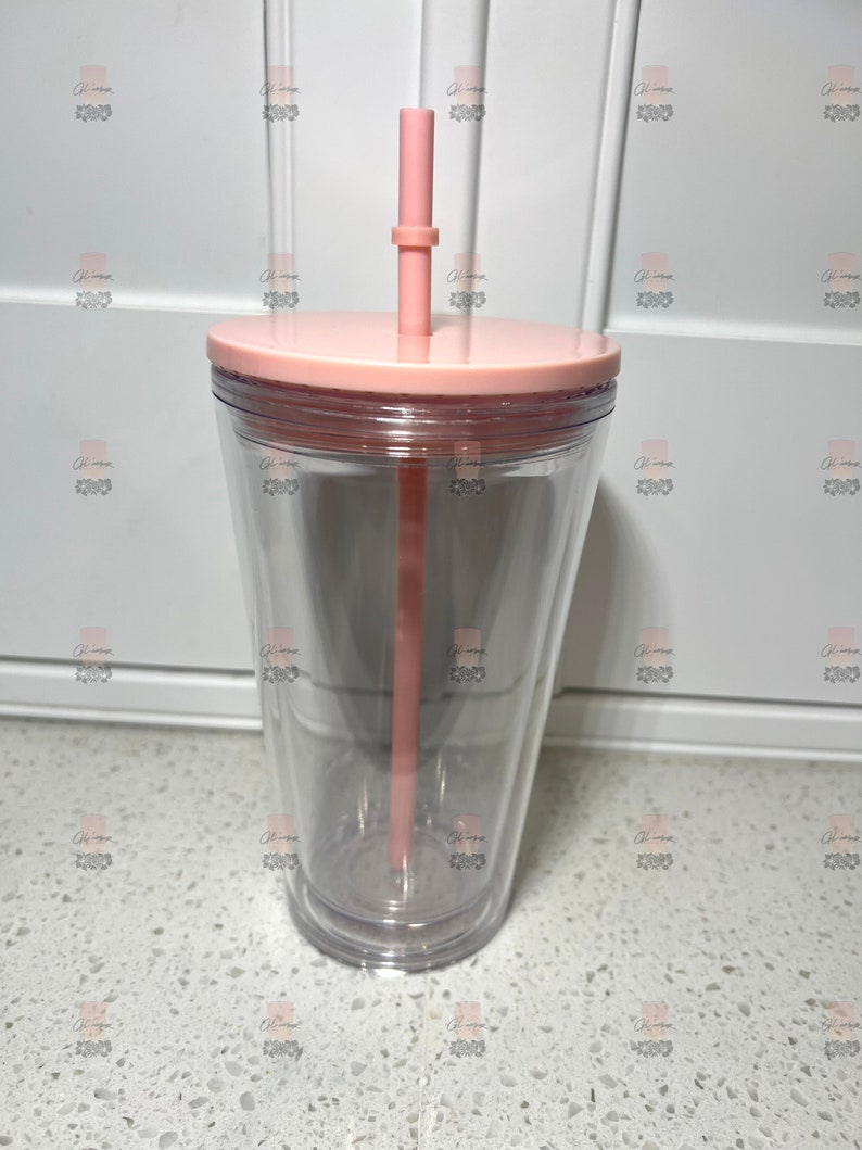 Puede incluir: Un vaso transparente de doble pared con tapa y pajita de color rosa claro. El vaso tiene un dise&ntilde;o c&oacute;nico y est&aacute; hecho de pl&aacute;stico transparente. La pajita es recta y tiene un peque&ntilde;o anillo cerca de la parte superior. La tapa es plana y encaja perfectamente en el vaso.
