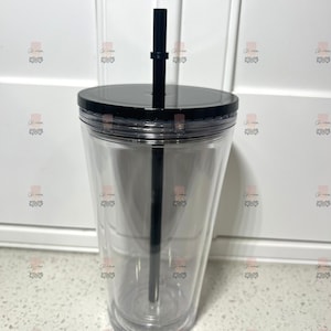 Puede incluir: Un vaso transparente de doble pared con tapa y pajita negras. El vaso est&aacute; vac&iacute;o, mostrando su dise&ntilde;o transparente. La pajita negra se extiende desde la tapa, lista para usar. Ideal para bebidas fr&iacute;as.