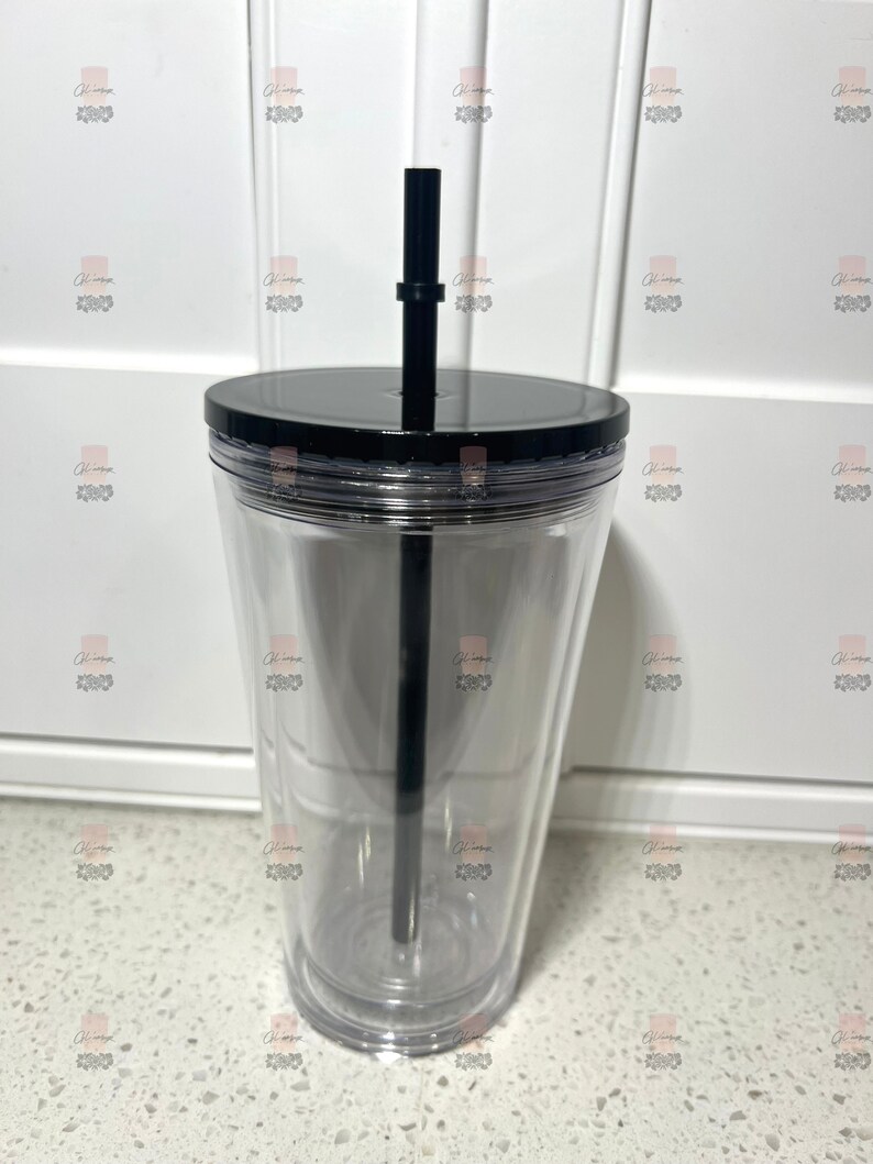 Puede incluir: Un vaso transparente de doble pared con tapa y pajita negras. El vaso est&aacute; vac&iacute;o, mostrando su dise&ntilde;o transparente. La pajita negra se extiende desde la tapa, lista para usar. Ideal para bebidas fr&iacute;as.