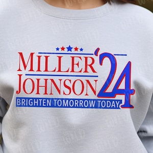 May include: A light blue sweatshirt with a red and blue political campaign design. The design features the text "MILLER JOHNSON 24" and the slogan "BRIGHTEN TOMORROW TODAY".