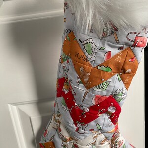 May include: A quilted Christmas stocking with a white faux fur cuff. The stocking is decorated with a patchwork design featuring various festive patterns, including gingerbread men, candy canes, and snowflakes.