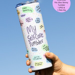 May include: A white 20 ounce skinny tumbler with a colorful design featuring the words "My Self-Care Tumbler" and a list of self-care activities. The tumbler is held in a hand with a straw sticking out of the top.