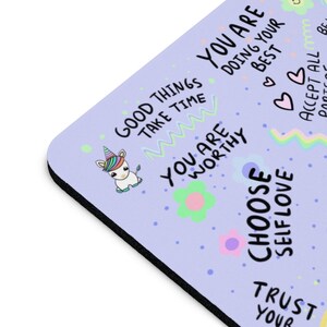 May include: A purple mouse pad with a unicorn, flowers, and positive affirmations. The text includes "Good Things Take Time", "You Are Worthy", "Choose Self Love", "Trust Your Best", and "Accept All Parts".