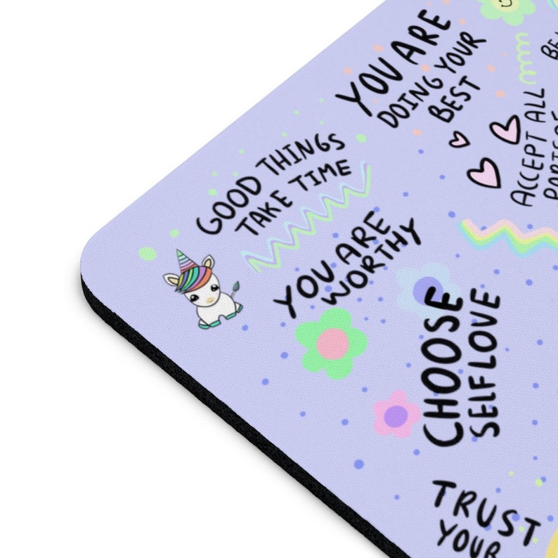 May include: A purple mouse pad with a unicorn, flowers, and positive affirmations. The text includes "Good Things Take Time", "You Are Worthy", "Choose Self Love", "Trust Your Best", and "Accept All Parts".