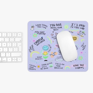 May include: Purple mouse pad with colorful illustrations and positive affirmations, including "Good things take time", "You are worthy", "Choose self love", "Keep growing", "Follow your dreams", "Everything will be okay", "Focus on your breathe", "Love the storms", "It's okay to feel sad", "Be gentle with yourself", "Shine bright", "Trust the process", "You are loved", "You are joy", "You are unique", "You are enough", and "Accept your parts".