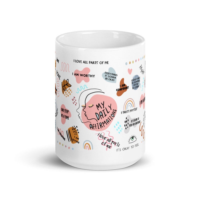 Puede incluir: Taza de cer&aacute;mica blanca con afirmaciones coloridas y el texto "My Daily Affirmations". El dise&ntilde;o incluye frases como "Amo todas mis partes" y "Soy valioso", junto con formas abstractas y un arco&iacute;ris.