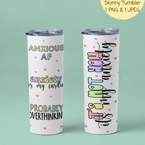 May include: Two white 20 ounce skinny tumblers with colorful text and pink hearts. The first tumbler says "Anxious AF" and "anxiety is my cardio" and "Probably Overthinking". The second tumbler says "It's not you, it's my anxiety".