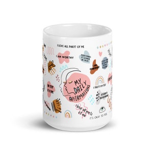 Puede incluir: Taza de cer&aacute;mica blanca con el texto "MY DAILY AFFIRMATIONS" y otras afirmaciones positivas. La taza presenta ilustraciones coloridas y frases como "I love all parts of me" y "I am worthy".