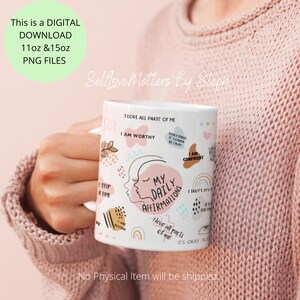 May include: White ceramic mug with a pink and blue design featuring the text "My Daily Affirmations" and positive affirmations. The mug is held by a hand wearing a pink sweater.
