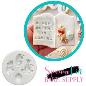 Puede incluir: Un molde de silicona para hacer galletas con temática de Winnie the Pooh. El molde presenta a Winnie the Pooh, Piglet, Eeyore y un tarro de miel. El molde es blanco y tiene una superficie lisa.