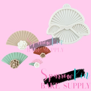 May include: A silicone mold for baking fan-shaped decorations. The mold has three different sizes of fans, with the largest fan at the top and the smallest fan at the bottom. The mold is white and has the text "LBS" in the top right corner.
