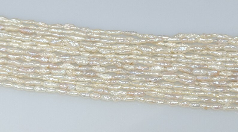 Cream Chinese Freshwater Long Rice Krispies 2.5-3.0 by 8.5mm pearl strand
