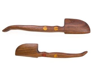 May include: Two wooden scoops with handles. The larger scoop has two gold accents on the handle. The smaller scoop has one red and one gold accent on the handle.