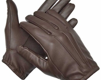 Op de afbeelding: Een paar bruine leren handschoenen met een gladde afwerking. De handschoenen hebben een eenvoudig ontwerp met een enkele naad die over de rug van elke vinger loopt.
