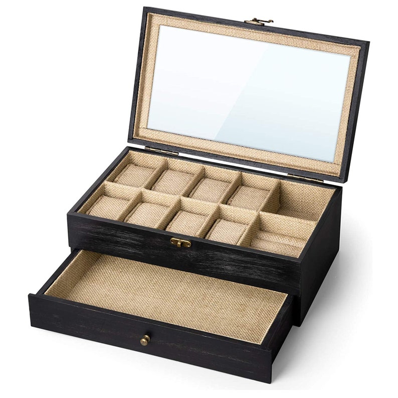 May include: Black wooden watch box with a glass top and a drawer. The box has nine compartments for watches and a lined interior.