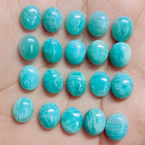 Pu&ograve; includere: Una collezione di gemme di Amazonite ovali in varie tonalit&agrave; di verde acqua e turchese. Le pietre lucide mostrano motivi naturali e sono disposte su una superficie chiara, evidenziando la loro finitura liscia e lucida. Ideali per la creazione di gioielli.