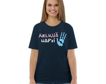 May include: Navy blue t-shirt with the text "KELKÜÄ HAPXÌ" in pink and light blue. The design includes a hand with the fingers making an "okay" sign. The shirt is made of a soft material.