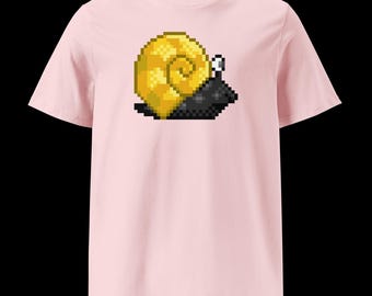 May include: A light pink t-shirt featuring a pixelated snail graphic. The snail has a yellow shell, a black body, and white antennae. The t-shirt is made of a soft material and has short sleeves.