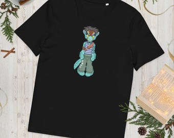 May include: A black short-sleeved t-shirt featuring a centered graphic of a teal-colored anthropomorphic creature with dark hair, wearing a striped shirt, a brown shoulder strap, and olive green pants with the text PHNX printed on the leg.