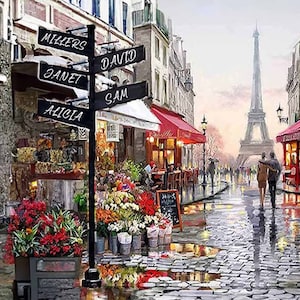 May include: A black signpost with white lettering pointing to different directions. The signpost is in front of a flower shop in a Parisian street scene. The signpost reads "Millers", "Janet", "Alicia", "Sam", and "David". The Eiffel Tower is in the background.