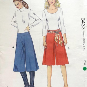 May include: Kwik Sew sewing pattern 3433 featuring two women's outfits. One outfit includes blue culottes and a white turtleneck. The other outfit includes red culottes and a white scoop neck top. Sizes XS-XL.