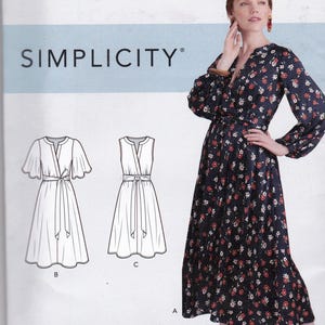 Puede incluir: Patrón de costura Simplicity K9041 para vestidos. El patrón incluye ilustraciones de diferentes estilos de vestidos, con una mujer modelando un vestido con estampado floral azul marino. La talla del patrón es U.S. (6-14).