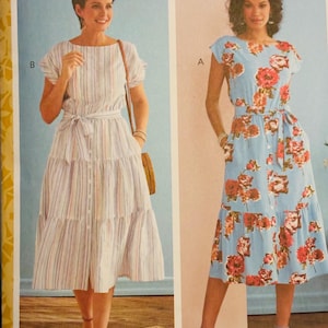 May include: Butterick sewing pattern B6722 featuring two women's dresses. One dress is light blue with a floral print, and the other is a striped pattern. The pattern includes sizes A5/E5 (6-22).