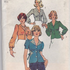 Peut inclure: Patron de couture Simplicity vintage 6576, présentant quatre modèles de chemisiers. Le patron est pour une taille 12 avec un tour de poitrine de 86 cm. Les chemisiers ont différents styles de manches et détails de boutons.