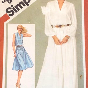 May include: A Simplicity 5265 Jiffy sewing pattern envelope for a dress. The cover features a white long-sleeved floor-length dress and a light blue sleeveless knee-length dress with a V-neckline, a gathered waist, and a belt. The text includes 5265, 16, and Jiffy.
