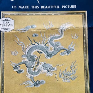 May include: A Repoussé embroidery kit featuring a detailed dragon design in shades of gray and white on a gold background. The kit includes genuine crewel yarn and a needle. The design measures 16.5 x 16.5 inches.
