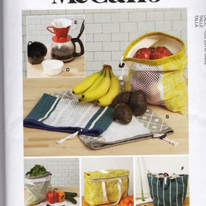 Könnte beinhalten: Ein McCall's-Schnittmuster mit verschiedenen wiederverwendbaren Einkaufstaschen, einer Kaffeemaschine und einer Tragetasche. Die Taschen sind in verschiedenen Größen und Designs erhältlich, darunter Netz- und gemusterte Stoffe. Das Bild zeigt auch Bananen, Avocados und andere Produkte.