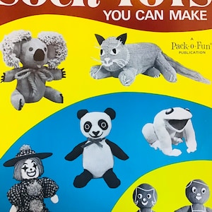 May include: A book cover featuring the title "More Sock Toys You Can Make" and illustrations of various sock toys, including a koala, a cat, a panda, a frog, a clown, and two dolls.