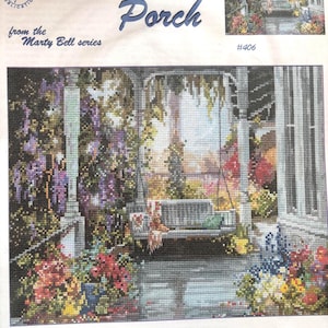 May include: A cross-stitch pattern named "Brenda's Porch" from the Marty Bell series. The design depicts a porch swing amidst vibrant flowers and wisteria. The image includes the text "Adaptation by Mildred Hinnant Hedgepath."