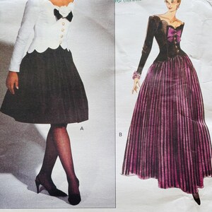 May include: Vogue Patterns sewing pattern showing two vintage dress designs. One dress has a white top with a black bow and a black skirt. The other dress has a black top with a purple bow and a purple and black striped skirt.