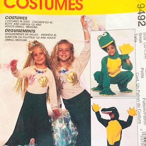 May include: A McCall's Costumes sewing pattern envelope 9492 featuring illustrations of mermaid costumes with long skirts and shell tops, a green frog costume with a hood, and a green alligator costume with a hood and yellow webbed hand covers.