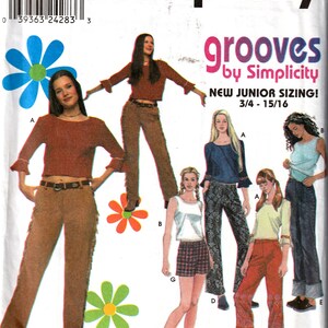 May include: A sewing pattern for girls' clothing, featuring five different outfits. The pattern is called "grooves by Simplicity" and includes a new junior sizing for ages 3/4 to 15/16. The outfits include a brown top with a brown pair of trousers, a blue top with a pair of black trousers, a white tank top with a plaid skirt, a green top with a pair of red trousers, and a blue top with a pair of blue jeans.