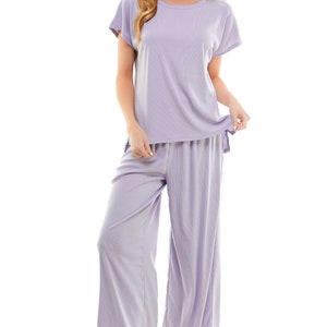 May include: A lavender two-piece lounge set with a short-sleeved top and wide-leg trousers. The set is made from a soft, comfortable fabric.