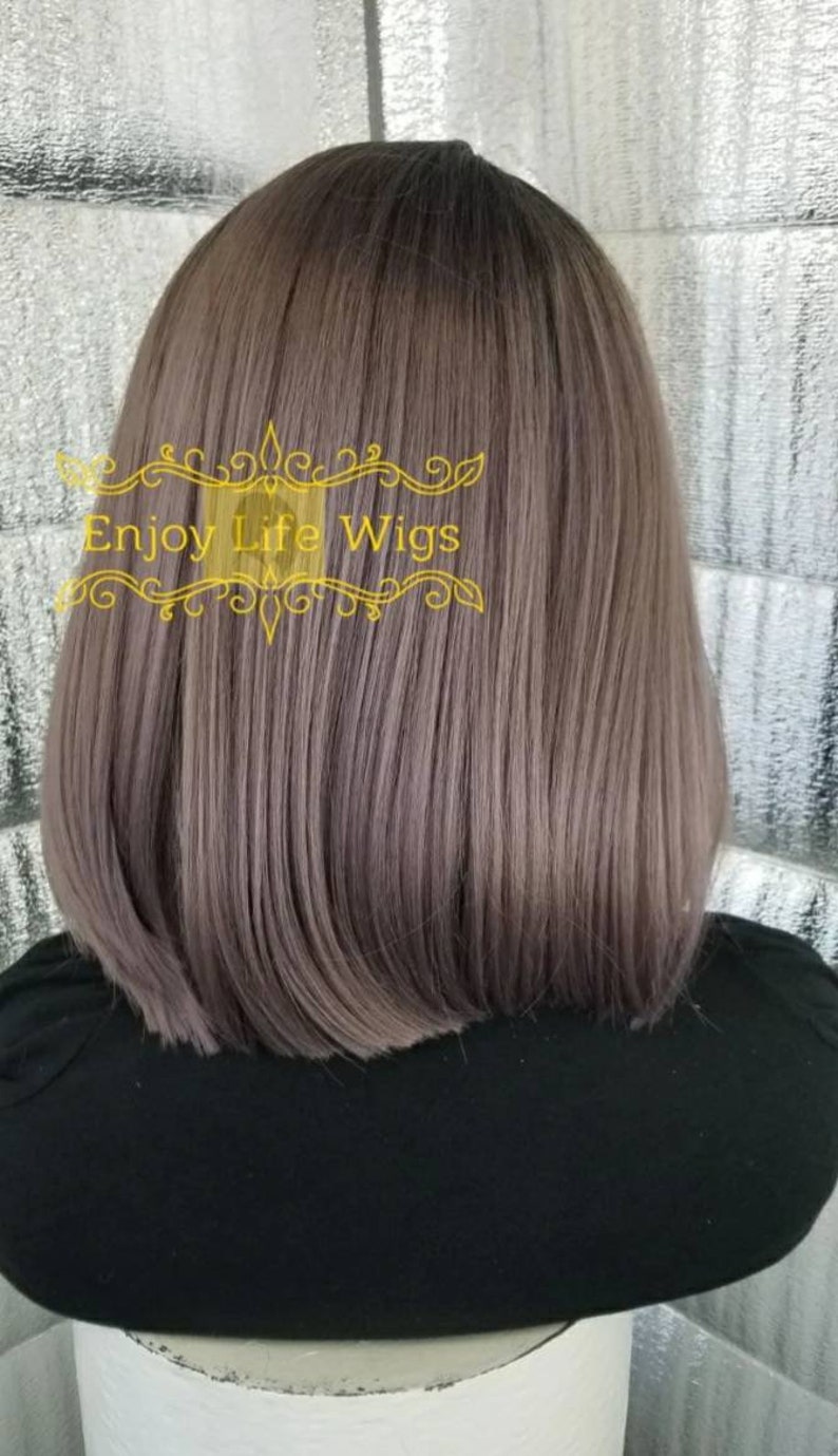 May include: A straight, shoulder-length wig in a light gray color. The wig is styled with a slight wave and has a natural-looking finish. The wig is displayed on a black mannequin head.