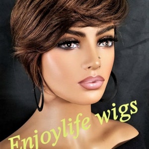 May include: A mannequin head with a short, layered brown wig. The mannequin has full makeup, including dark eye shadow and pink lipstick. The text "Enjoylife wigs" is written in a light green color.