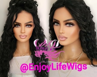 May include: A black curly human hair wig on a mannequin head. The wig is styled with a side parting and loose waves. The mannequin is wearing a white shirt and a gold necklace. The text "@EnjoyLifeWigs" is visible in the image.