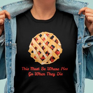 May include: Black t-shirt featuring a graphic of a berry pie and the text "This Must Be Where Pies Go When They Die" in red.