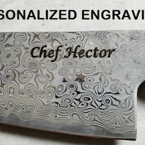 Puede incluir: Primer plano de un cuchillo de chef con una hoja estampada y un mango de madera. La hoja est&aacute; grabada con el texto "Chef Hector".