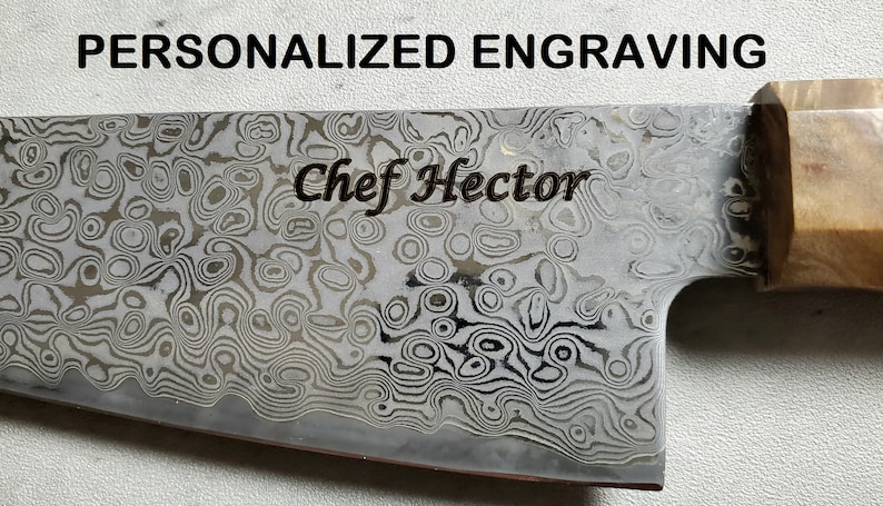 Puede incluir: Primer plano de un cuchillo de chef con una hoja estampada y un mango de madera. La hoja est&aacute; grabada con el texto "Chef Hector".