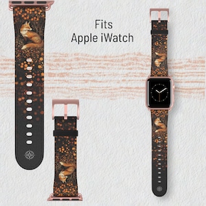 May include: A black Apple Watch band with a fox design. The band features a rose gold buckle and connectors. The fox is depicted in a forest setting with orange and yellow accents. The text "Fits Apple iWatch" is also visible.