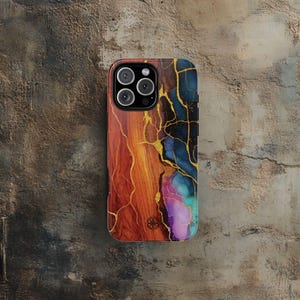 Puede incluir: Funda de tel&eacute;fono colorida con un dise&ntilde;o &uacute;nico. La funda presenta una mezcla de tonos naranja, rojo, azul y morado con acentos dorados en forma de vetas. La funda del tel&eacute;fono tiene un m&oacute;dulo de c&aacute;mara con tres lentes.